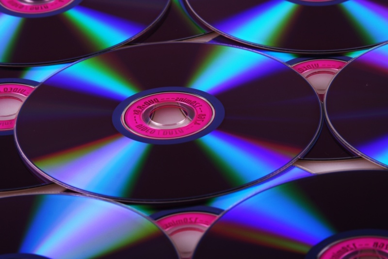 A series of CD or DVD disks showing light difracted from their shiny surfaces.