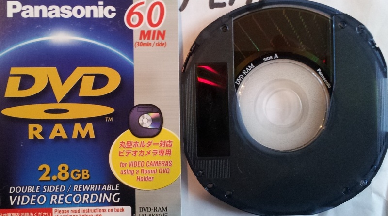 A Panasonic mini DVD-RAM disk 8cm and its cover inlay card. The disk's easily show where video was recorded by the darker inner circle area near the disc centre.