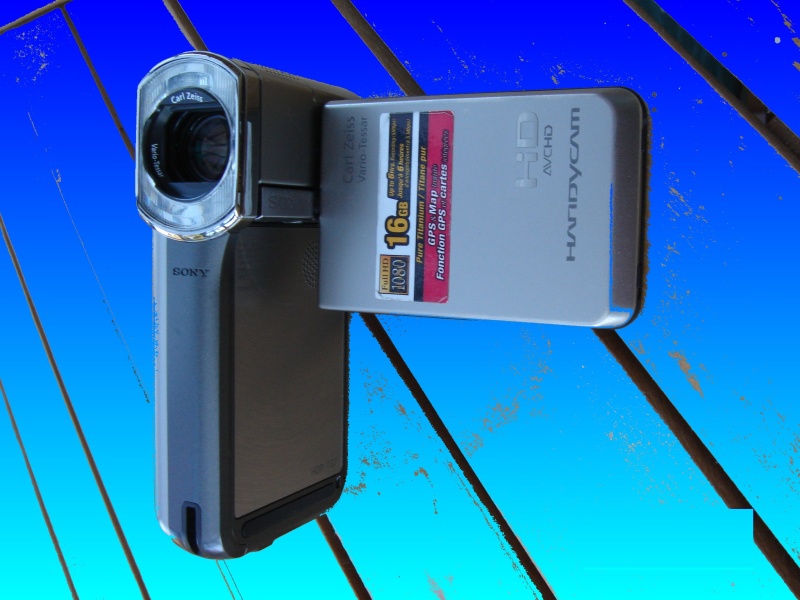 A Sony HDR AVCHD video camera with internal memory used to record 1080 HD video. The camera has a vertical form factor and Carl Zeiss lense, which is shown against a blue background in the photo.