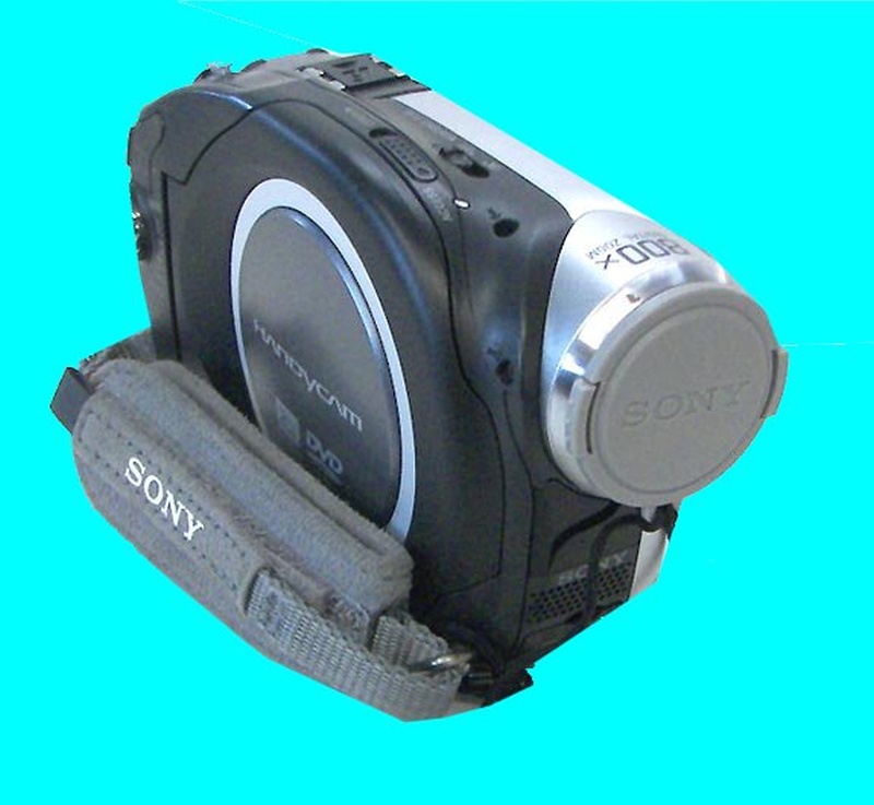 A Sony DCR-DVD handycam is shown in the photo against a blue background. The camera is forward facing and turned off with it's lense cover closed. This particular dvd cam was dropped and failed to finalize the disc.