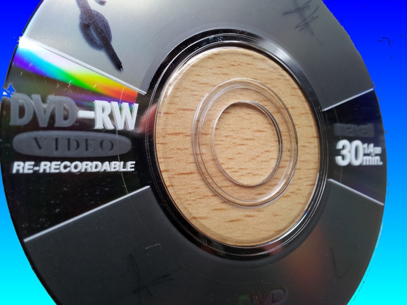 A Maxell DVD-RW in close up image of the label and reflective surface. This disk was used in a Canon Camcorder which failed to finalise the disk and ended with the message Recovering Data Task in progress. Consequently, the disk was later sent to us for recovery of the video.