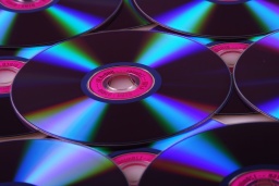 A series of CD or DVD disks showing light difracted from their shiny surfaces.
