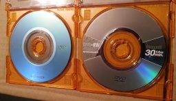 A mini Sony DVD-R shown alongside a Maxell DVD-R. Both discs were used in handycam video recorders reporting corrupt video files. The disks were sent to us to recover the video clips. 